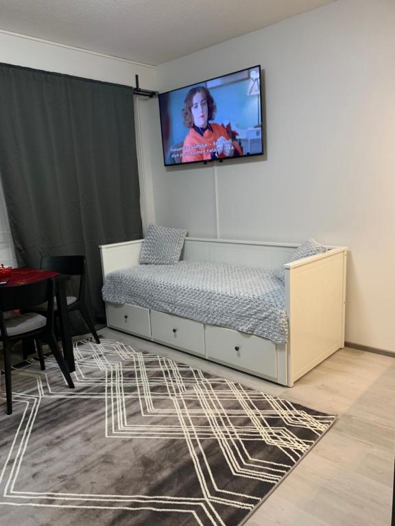 a bedroom with a bed with a tv on the wall at Yksiö keskustassa saunalla in Iisalmi