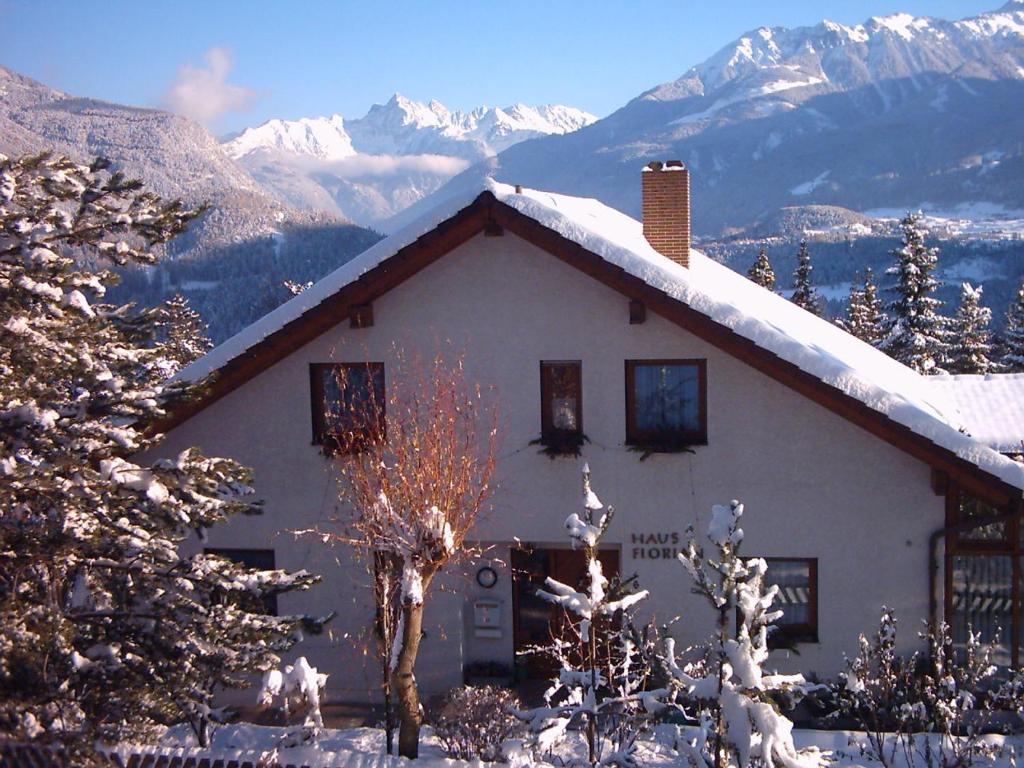 a house in the snow with mountains in the background at Apart Haus Florian in Imst