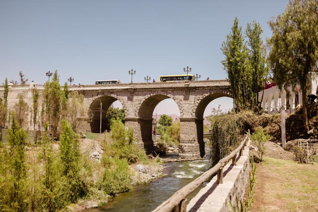 un puente sobre un río con un tren en él en La Posada del Puente en Arequipa