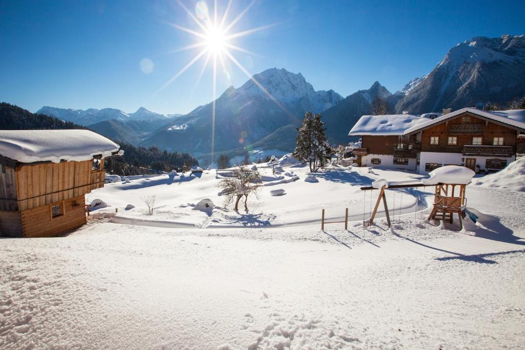 une montagne enneigée avec le soleil en arrière-plan dans l'établissement Alpenpension Ettlerlehen Ferienwohnungen, à Ramsau bei Berchtesgaden