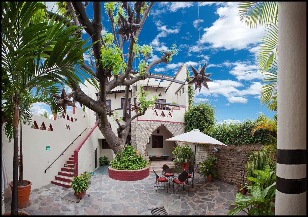 a white building with a tree and some chairs at Hotel Casa Blanca in Ajijic