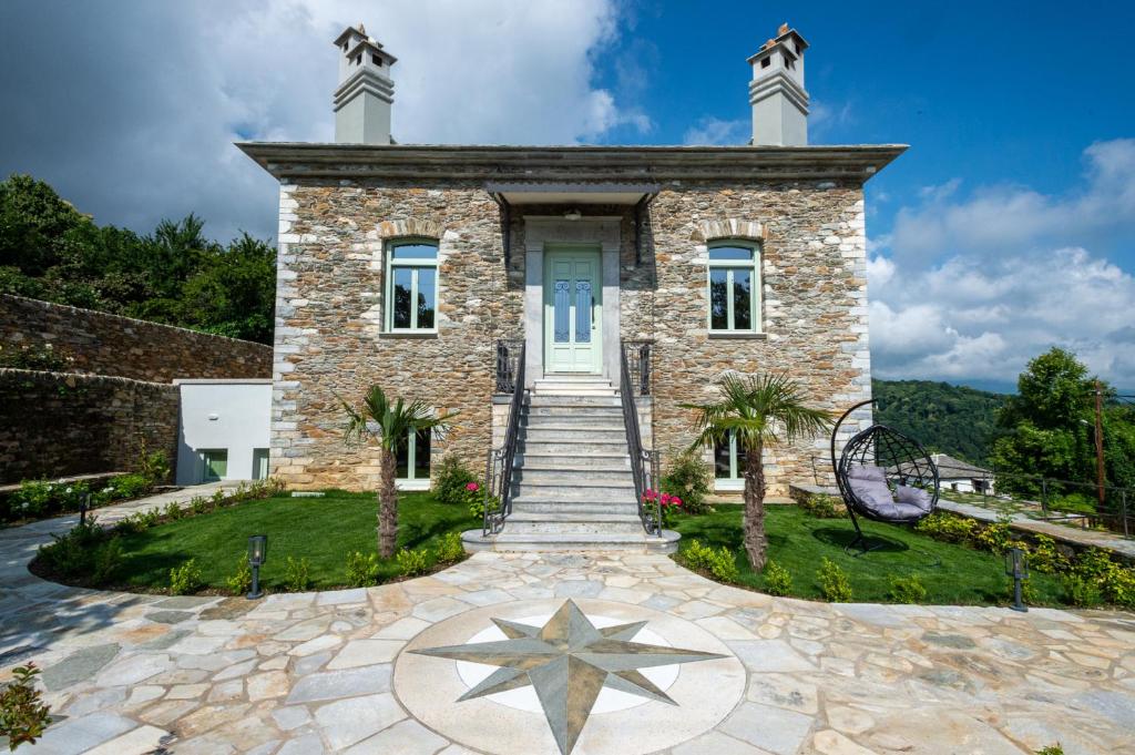 a stone house with a star in front of it at Nostos Country House in Tsagarada
