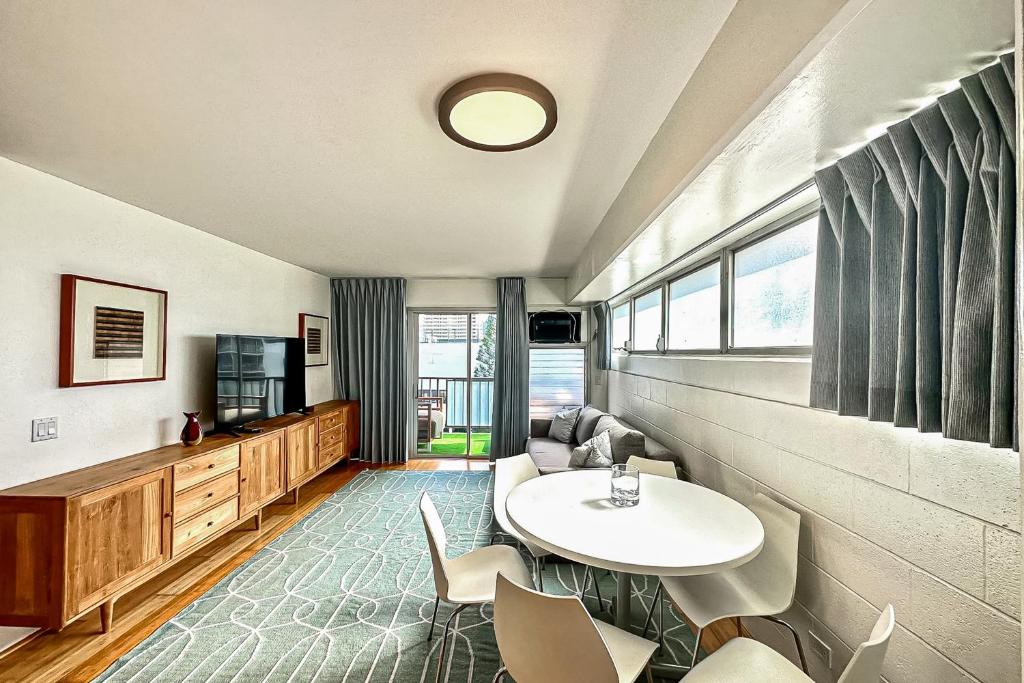 a living room with a white table and chairs at Waikiki Haven in Honolulu