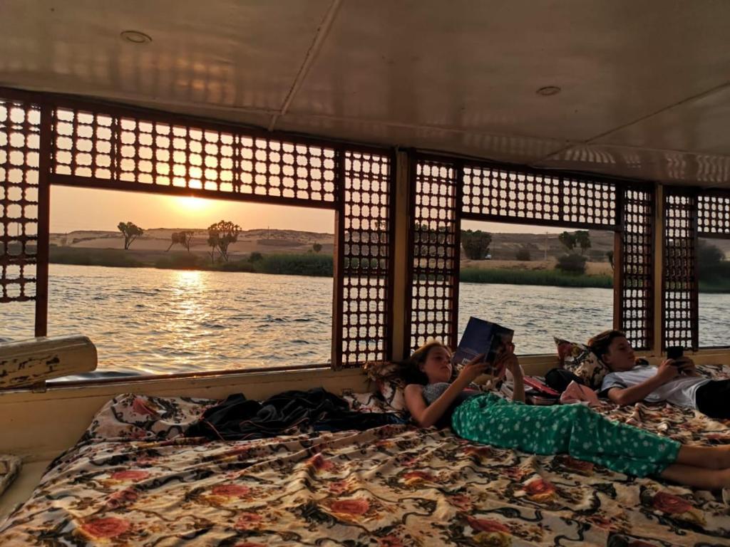 a group of children laying on a bed in a boat at Aswan Nile Felucca hotel in Aswan