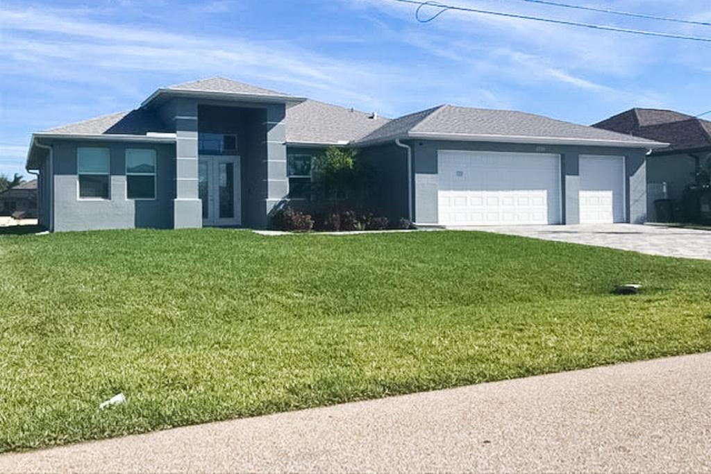a house with a green lawn in front of it at Bliss Bungalow in Cape Coral