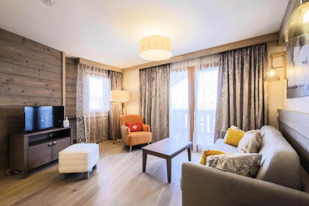 ein Wohnzimmer mit einem Sofa und einem TV in der Unterkunft Résidence Premium L'Hévana - maeva Home - Appartement 3 pièces 6 personne 844 in Les Allues