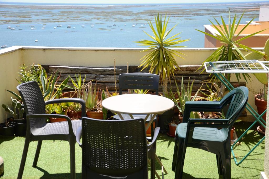 a table and chairs on a patio with a view of the ocean at Ria Terrace Apartment III in Faro