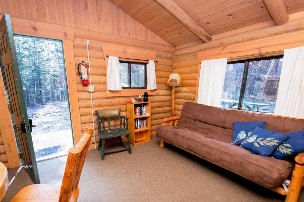 a living room with a couch in a log cabin at Experience Montana Cabins - Birdsong #2 in Bigfork