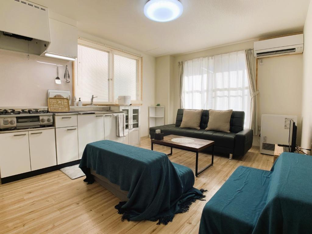 a kitchen and living room with a couch and a table at Shinsanjo Building - Vacation STAY 15855 in Asahikawa