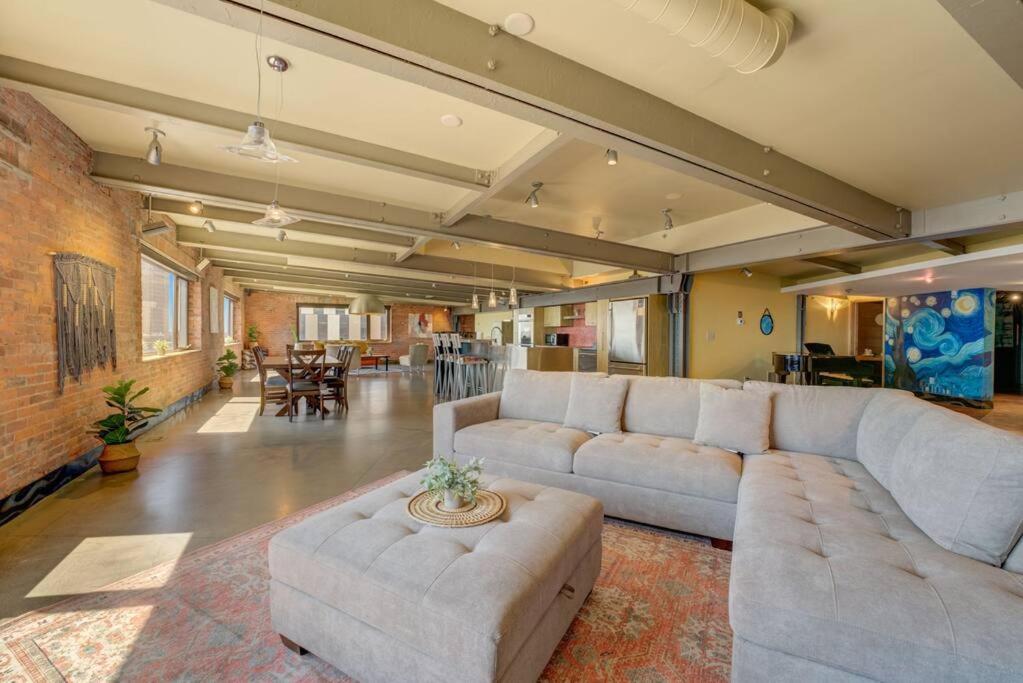 ein großes Wohnzimmer mit Sofas und Ziegelwand in der Unterkunft 1600 KCM Penthouse Apartment in Cleveland