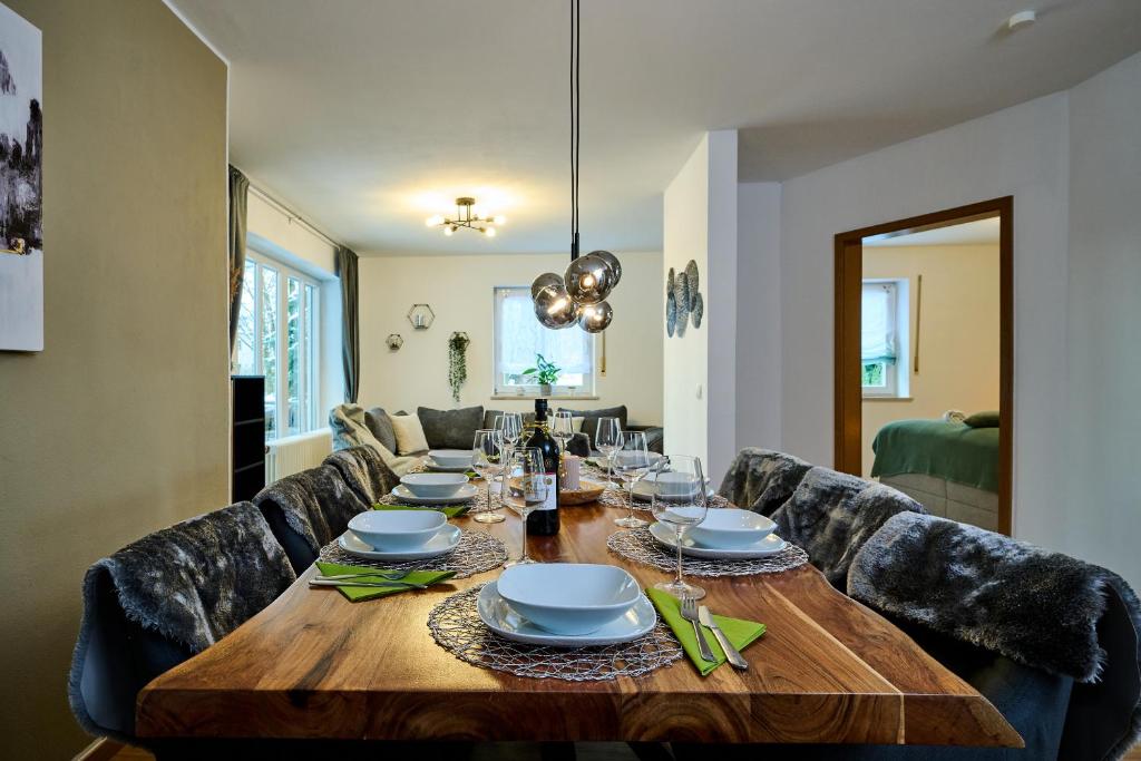 - une salle à manger avec une table et des chaises en bois dans l'établissement apanoxa homes I zentral I Parkplätze I Deluxe Apartment, à Straubing