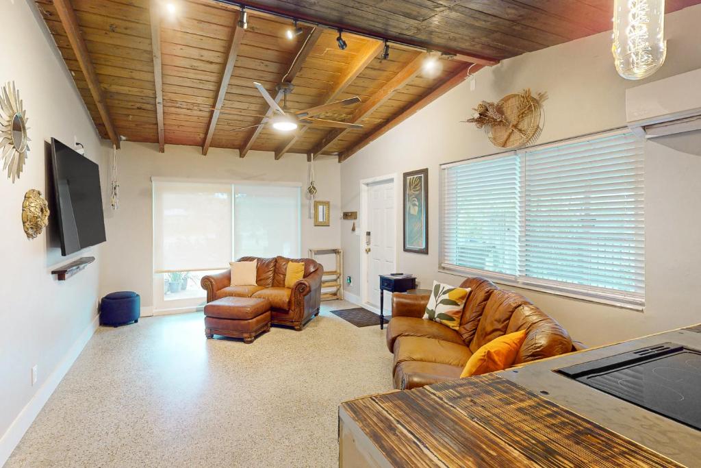 uma sala de estar com sofás de couro e uma televisão em Solstice Oasis em Fort Lauderdale