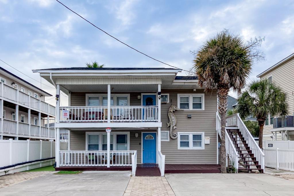 una casa con una puerta azul y una palmera en Seahorse Serenity, en Myrtle Beach