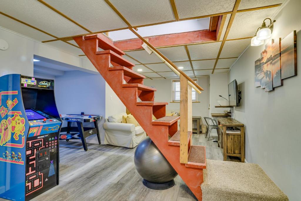 a living room with a staircase and a room with a table at Hot Tub and Resort Amenities Pocono Lake Retreat! in Pocono Lake