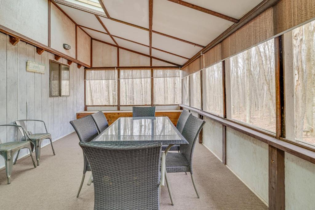 a dining room with a glass table and chairs at Hot Tub and Resort Amenities Pocono Lake Retreat! in Pocono Lake