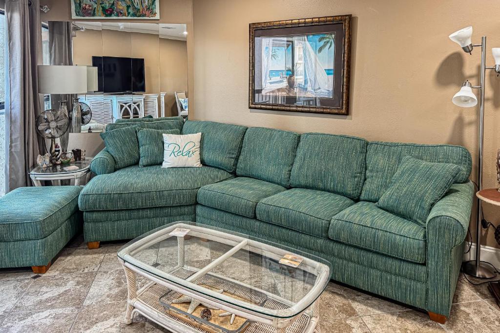 Una sala de estar con un sofá verde y una mesa. en Gulfside Townhomes 23, en Gulf Shores