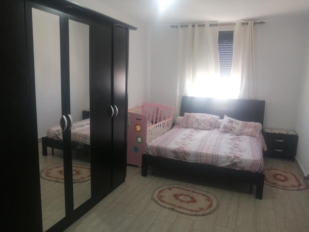 a bedroom with two beds and a crib and a window at F3 haut standing in Oran