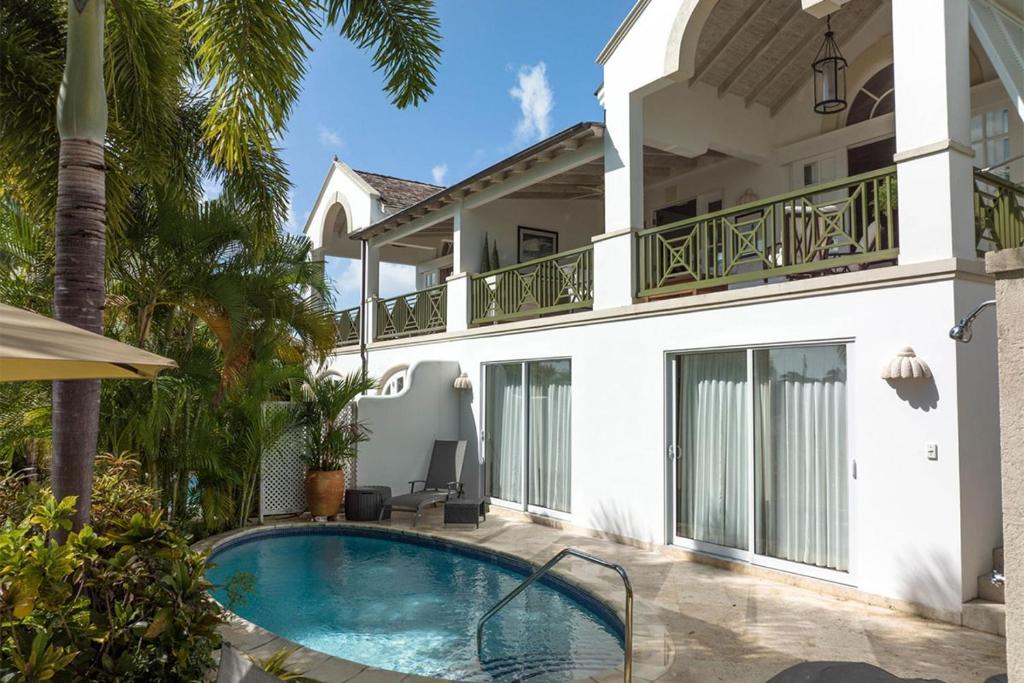 a villa with a swimming pool in front of a house at Royal Westmoreland - Sugar Cane Ridge 3 townhouse in Saint James