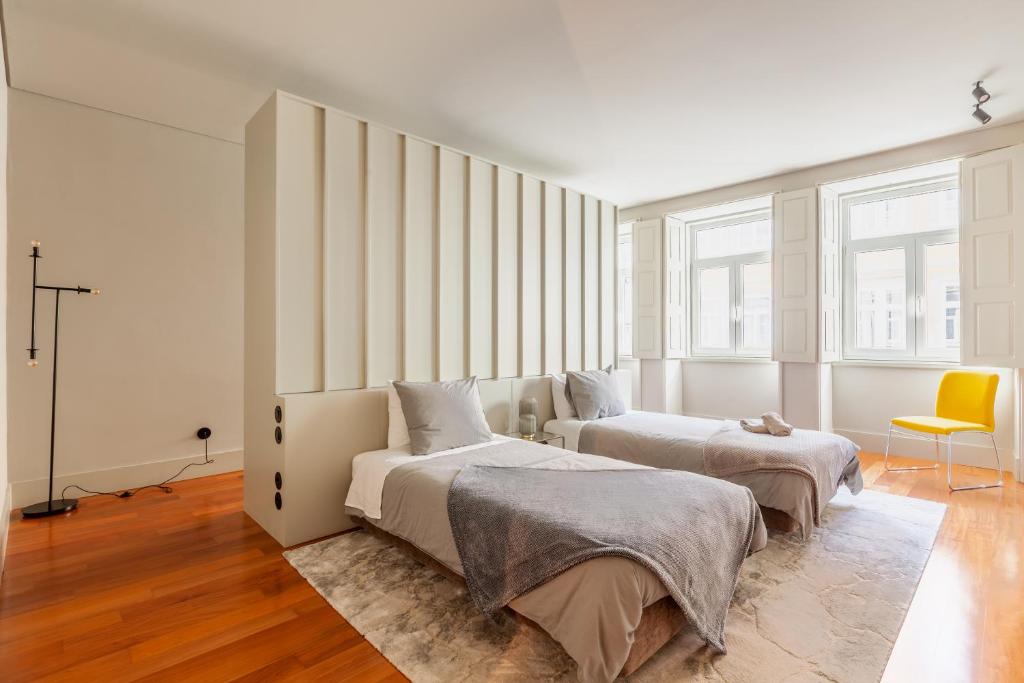 1 dormitorio con 2 camas y silla amarilla en Sta. Catarina 618 Suite, en Oporto