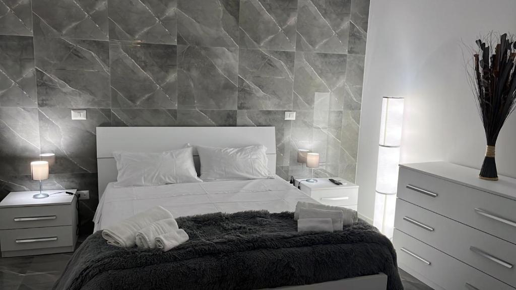 een slaapkamer met een wit bed en twee nachtkastjes bij Holiday Home Litteri in Catania