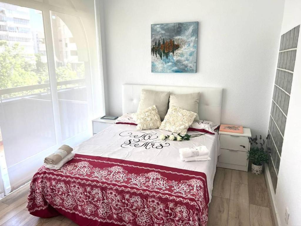 sypialnia z łóżkiem z czerwoną i białą narzutą w obiekcie Light and cozy apartment in Alicante w Alicante