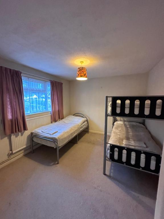 a bedroom with two bunk beds and a window at Rochester town centre beautiful 3-Bedroom House with garden in Strood