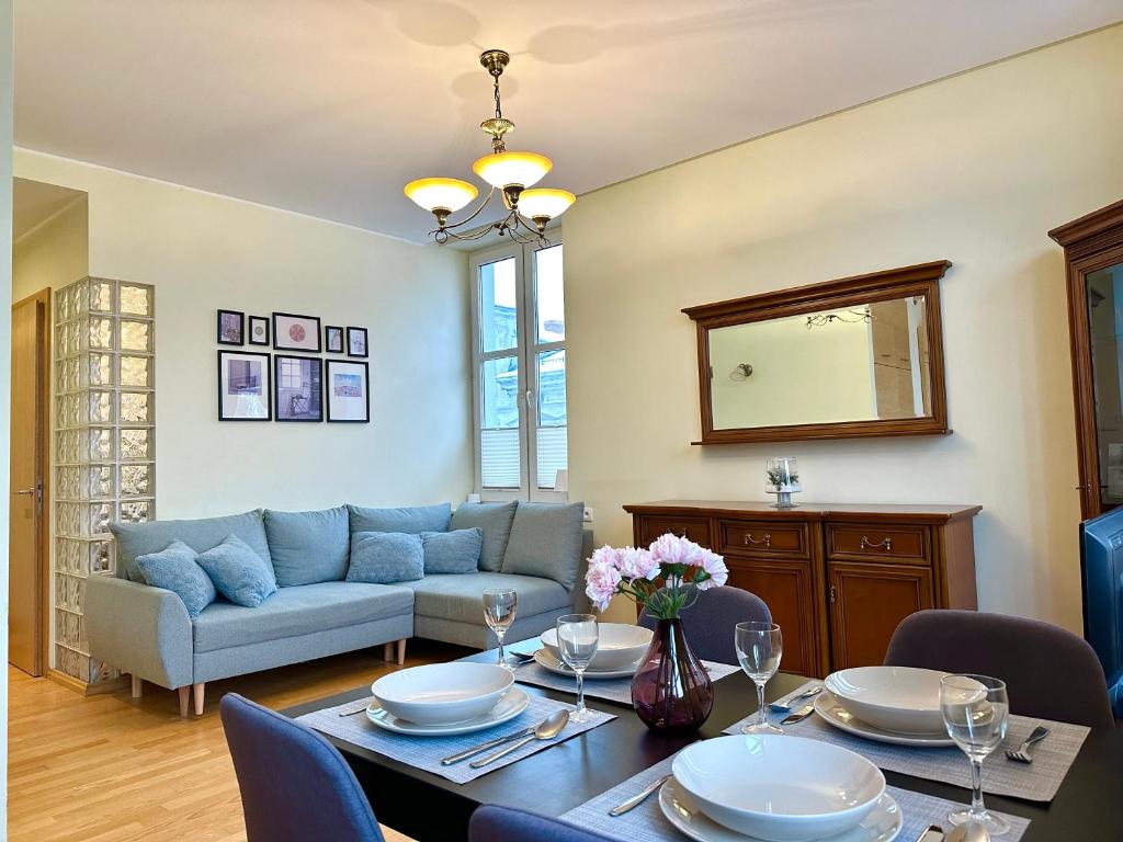 a living room with a table and a couch at Apartament z widokiem na stary rynek in Wejherowo