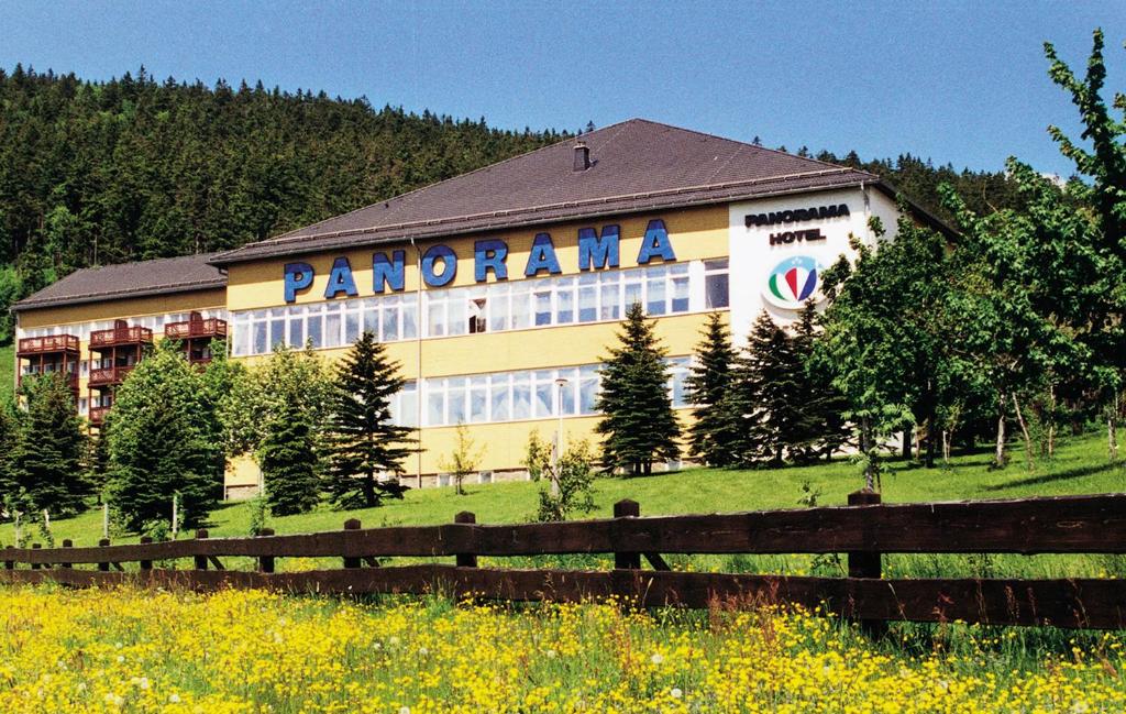 un grand bâtiment avec un panneau sur son côté dans l'établissement Panorama Hotel Oberwiesenthal, à Kurort Oberwiesenthal