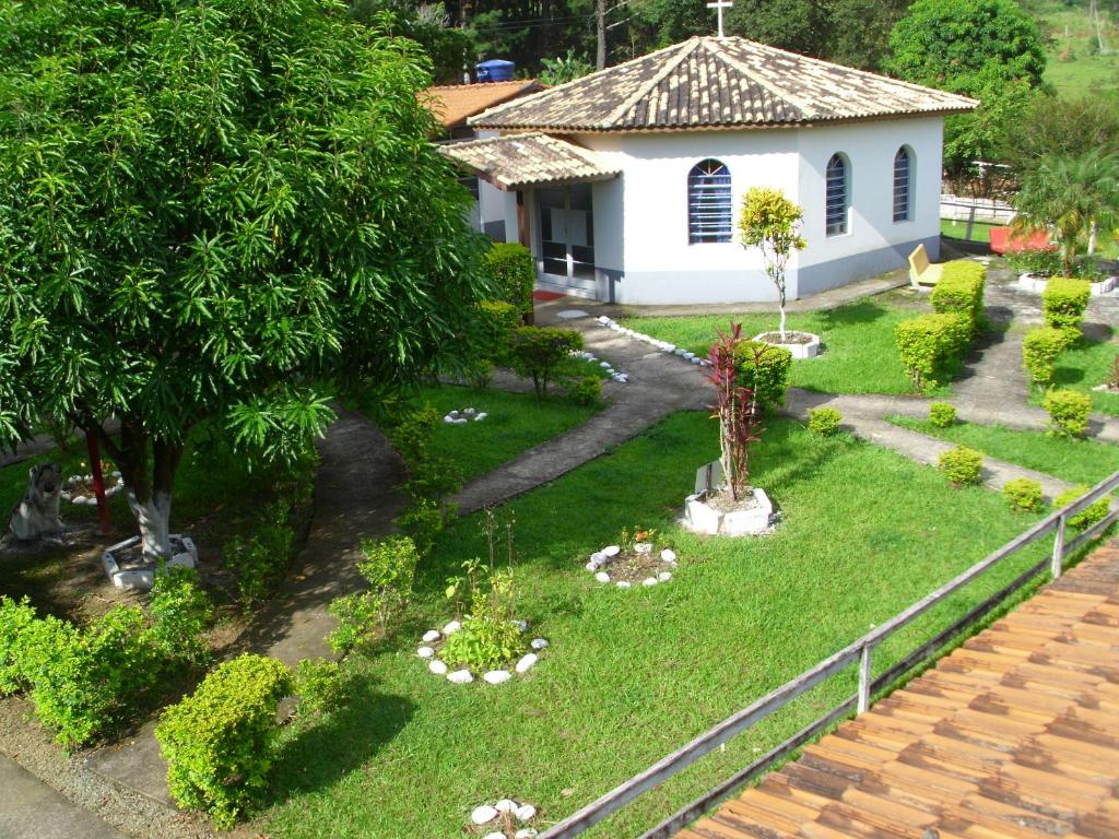 una pequeña casa blanca con un patio con plantas en Comunidade Anuncia-Me, en Guaratinguetá