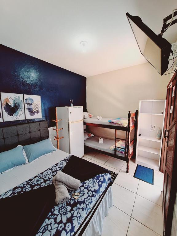 a small bedroom with a bed and a refrigerator at Pousada JOSHUA in Penha