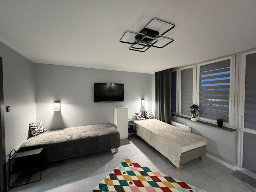 um quarto com 2 camas e uma televisão de ecrã plano em Apartament Na Wspólnej em Sosnowiec