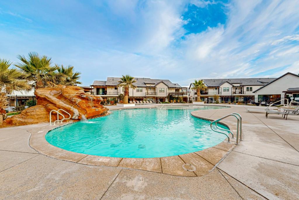 a swimming pool in a resort with palm trees and houses at Santa Clara Starlight-Ocotillo 9 in Santa Clara