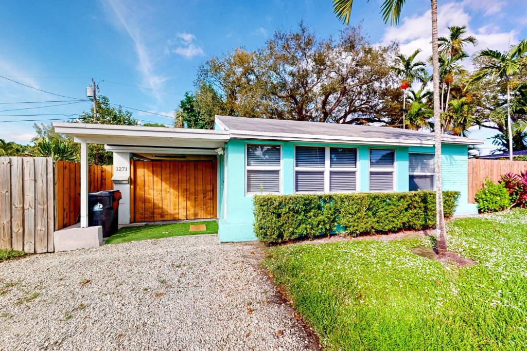 una casa azul con una valla delante de ella en Palm Shadow Sanctuary en Fort Lauderdale