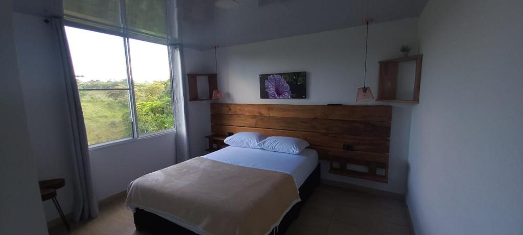 a bedroom with a bed and a large window at JARDIN CAFETERO in Trujillo