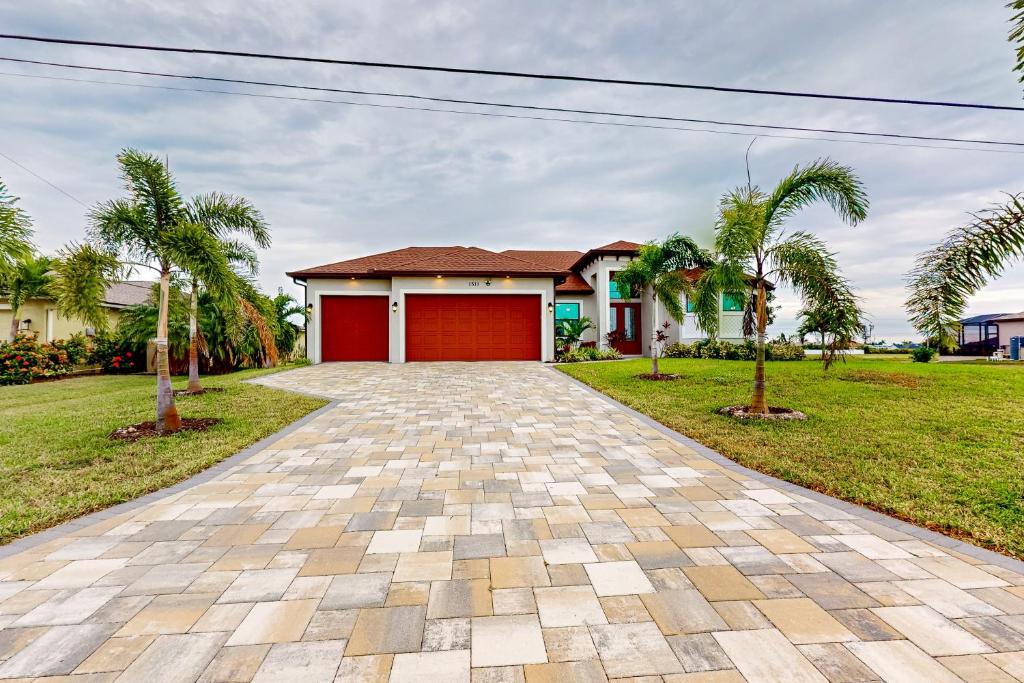 a house with a red garage and palm trees at Palm & Friends Estate in Cape Coral