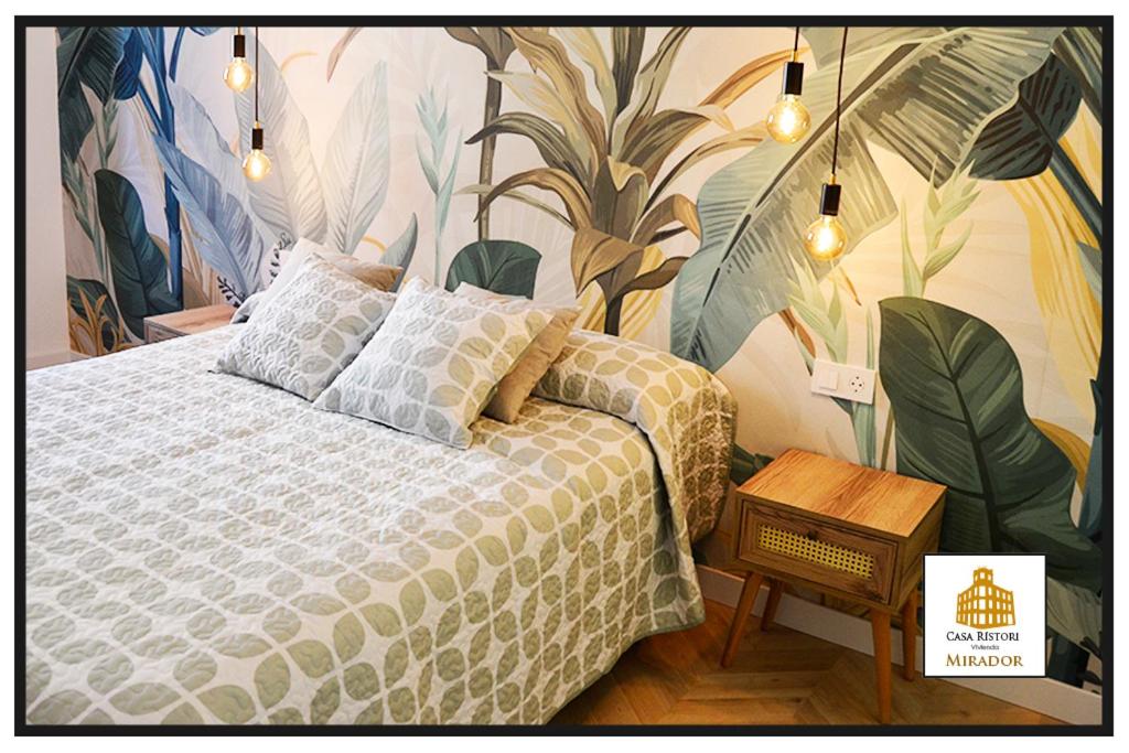 a bedroom with a bed with a mural of plants at Casa Rístori Mirador in Manzanares