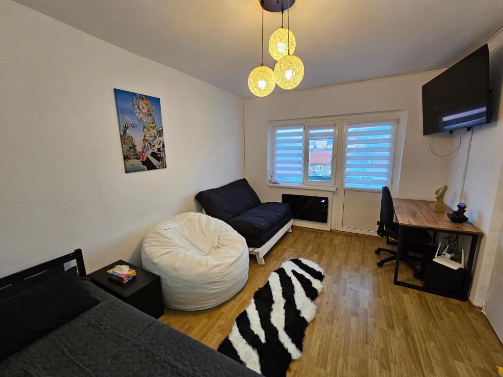 TV a/nebo společenská místnost v ubytování Black & White, Rezerva acum garsoniera cozy, cafea Lavazza, balcon, priveliște spre munte, saltea premium, fotoliu puf