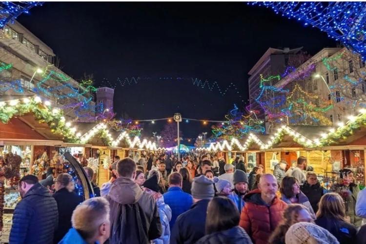 a crowd of people walking down a street with christmas lights at ROYAL WILLIAM YARD Luxury Apartments at "THE BRUCE" - FAMILY APARTMENT and Connecting DELUXE STUDIO - PRIVATE connecting lobby so BOOK BOTH For LARGER GROUPS - FREE ONSITE PARKING in Plymouth