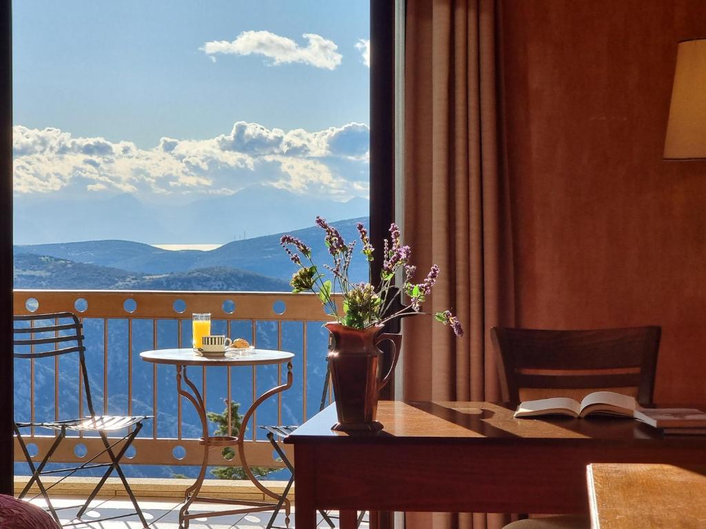 a room with a table with a view of a balcony at Likoria Hotel in Arachova