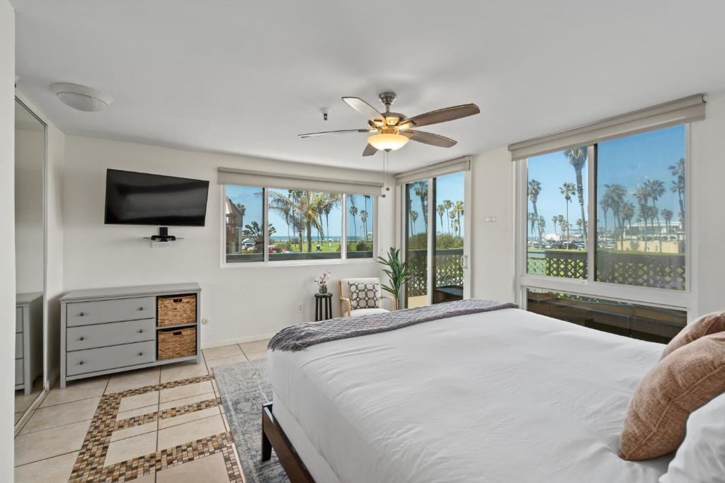 a bedroom with a bed and a flat screen tv at Belmont Ocean Views - Massive Private Deck, Grill & Parking in San Diego