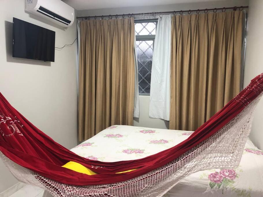 a red hammock in a bedroom with a bed at Sejam Bem Vindos ao Nucleo Bandeirante Aeroporto 102 in Núcleo Bandeirante