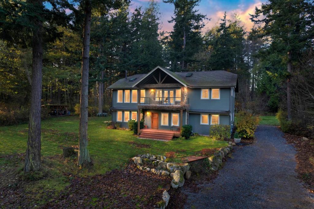 a house in the woods with the lights on at Las Casas Feliciano - Lummi Island in Lummi Island