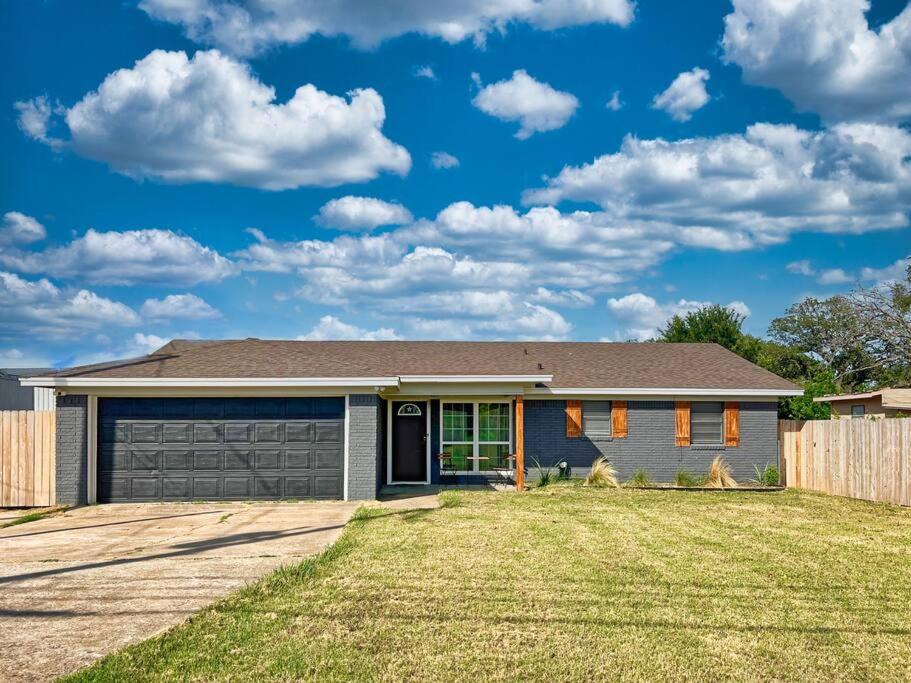 a house with a garage and a fence at New Cozy Home 10 Min to Magnolia and Baylor in Waco