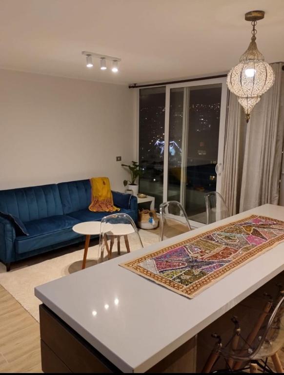 a living room with a blue couch and a table at Departamento central viña in Viña del Mar