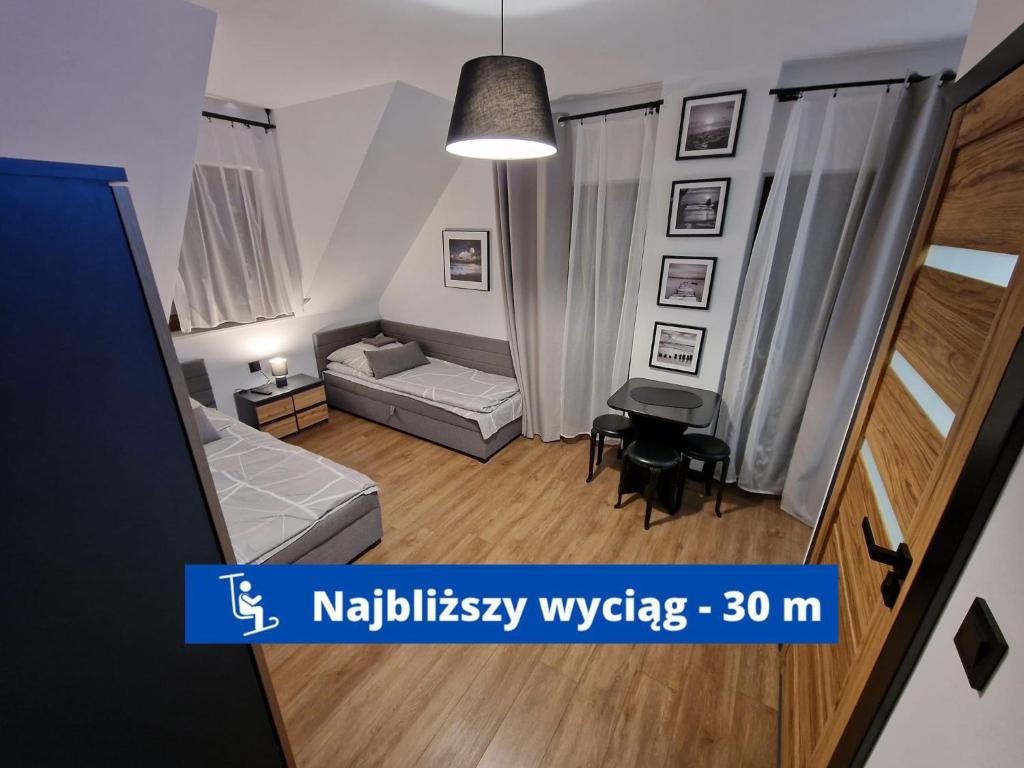 uma pequena sala de estar com um sofá e uma mesa em Przy Ostrewkach Małe Ciche em Murzasichle