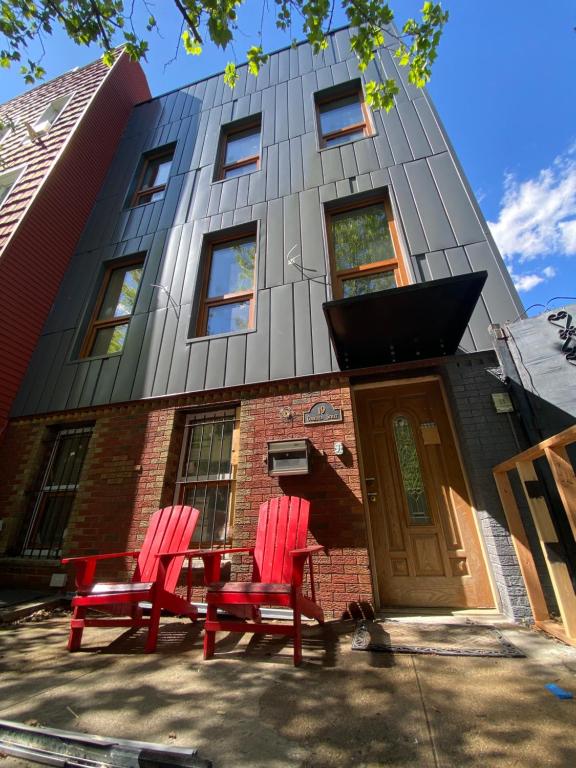 two red chairs sitting in front of a building at Cozy Garden Apt in Williamsburg NYC Townhouse in Brooklyn