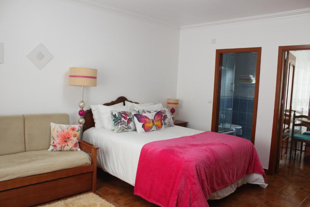 ナザレにあるSolar do Diabreteのベッドルーム1室(ピンクの毛布と椅子付きのベッド1台付)