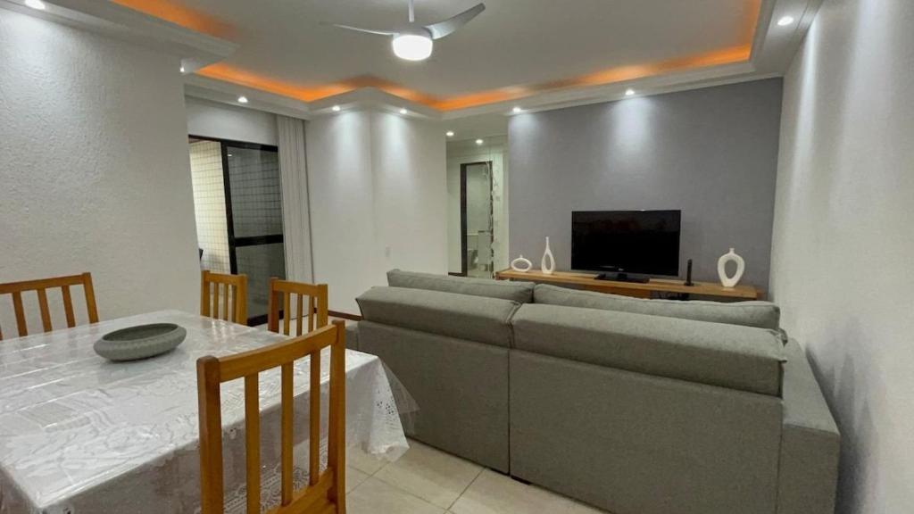 - un salon avec un canapé, une table et une télévision dans l'établissement Cabo Frio Elegance Apartament, à Cabo Frio