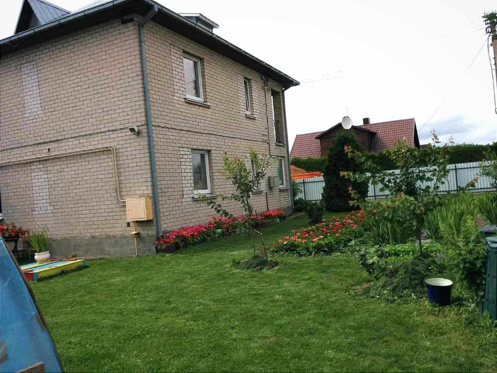 una casa con un jardín con flores delante en Town House en Kėdainiai