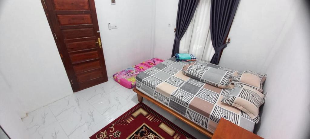 een slaapkamer met 2 bedden in een kamer met een deur bij Bumi Homestay in Painan